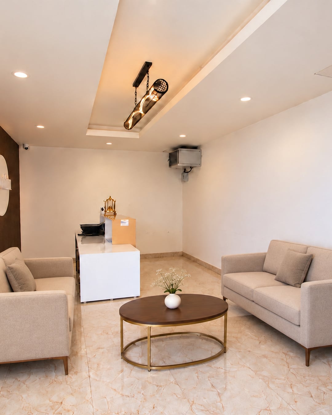 Old Mill reception lounge with ivory sofas and a round brass-framed table