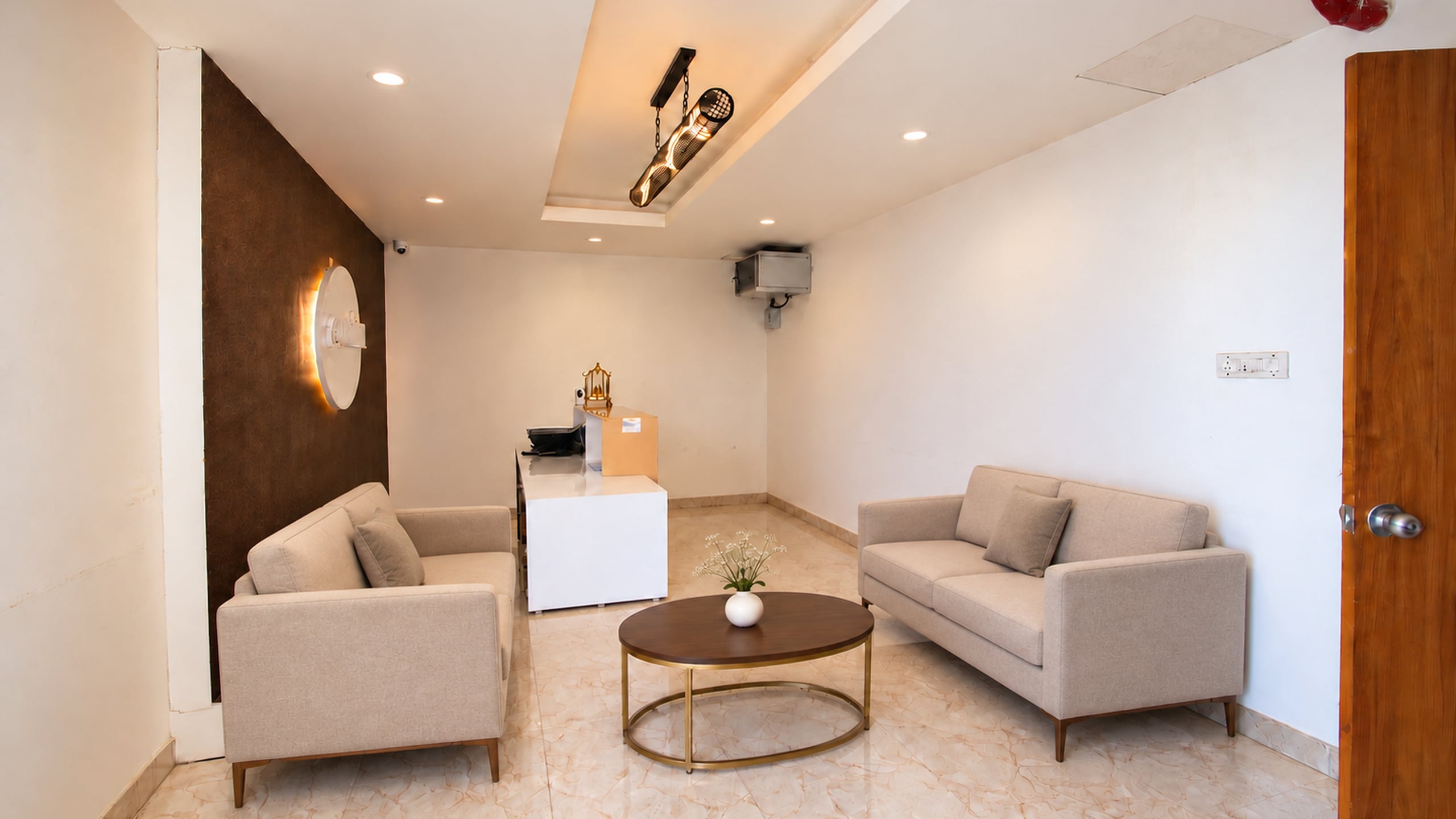 Old Mill reception lounge with ivory sofas and a round brass-framed table