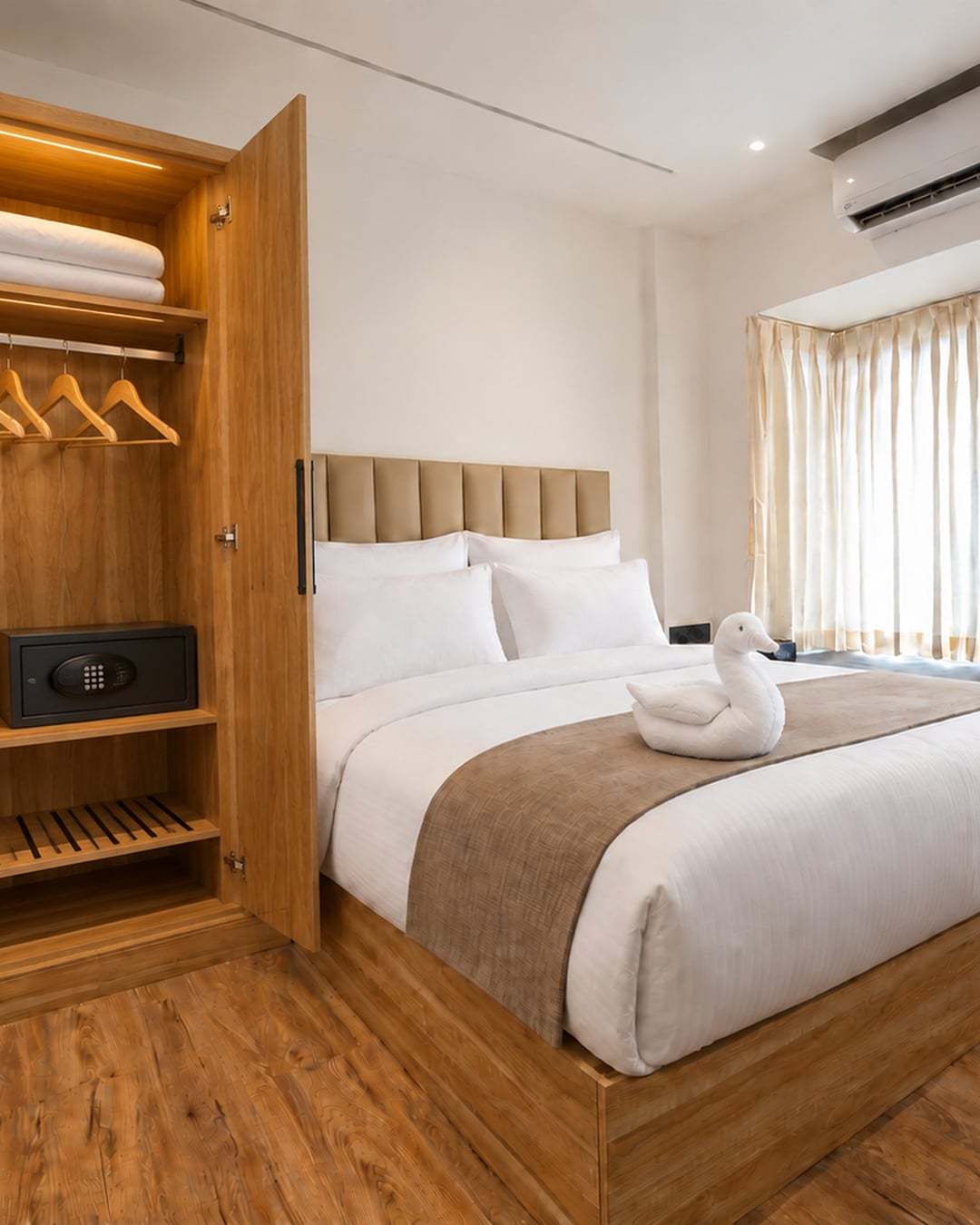 Guest room with an open timber wardrobe, hangers and an in-room safe