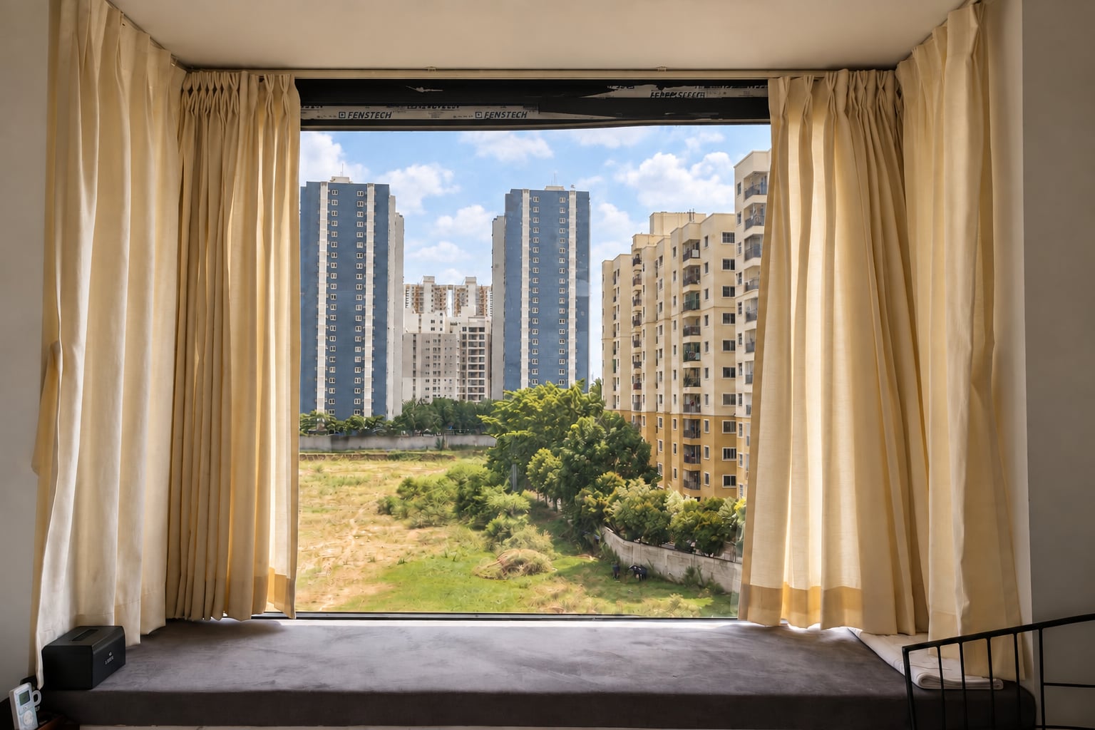 Guest-room window seat overlooking the greenery and buildings of East Bengaluru